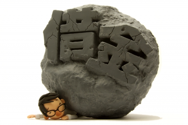 お金の上でうなだれる。南アルプス市の司法書士や弁護士に無料で相談できます